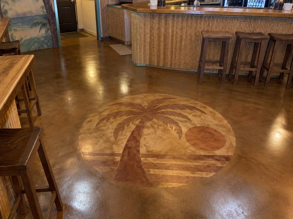 Stained palm tree and sun logo emblem in a restaurant concrete floor